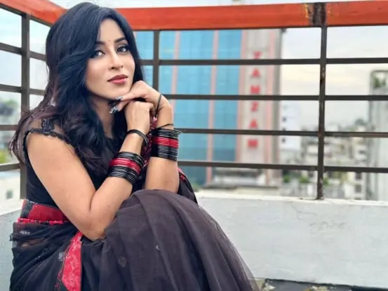 Sumona seated on a rooftop balcony during a photo shoot